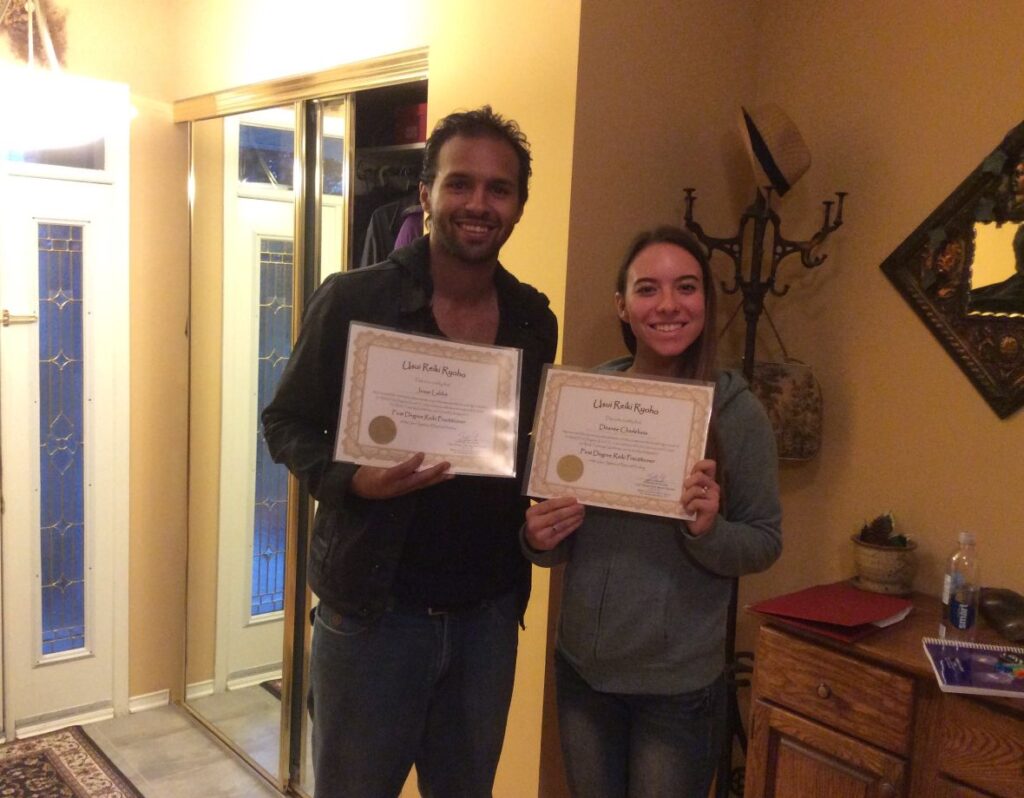 Two people holding certificates in a living room.