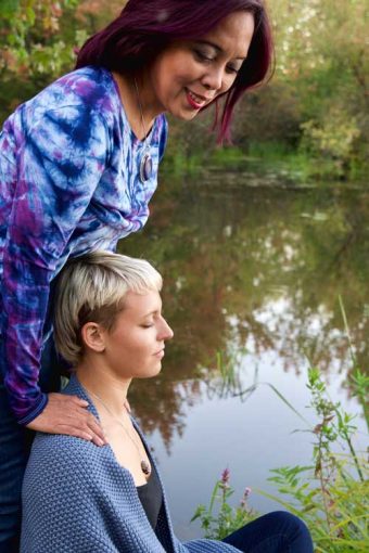 A woman is standing next to another person.